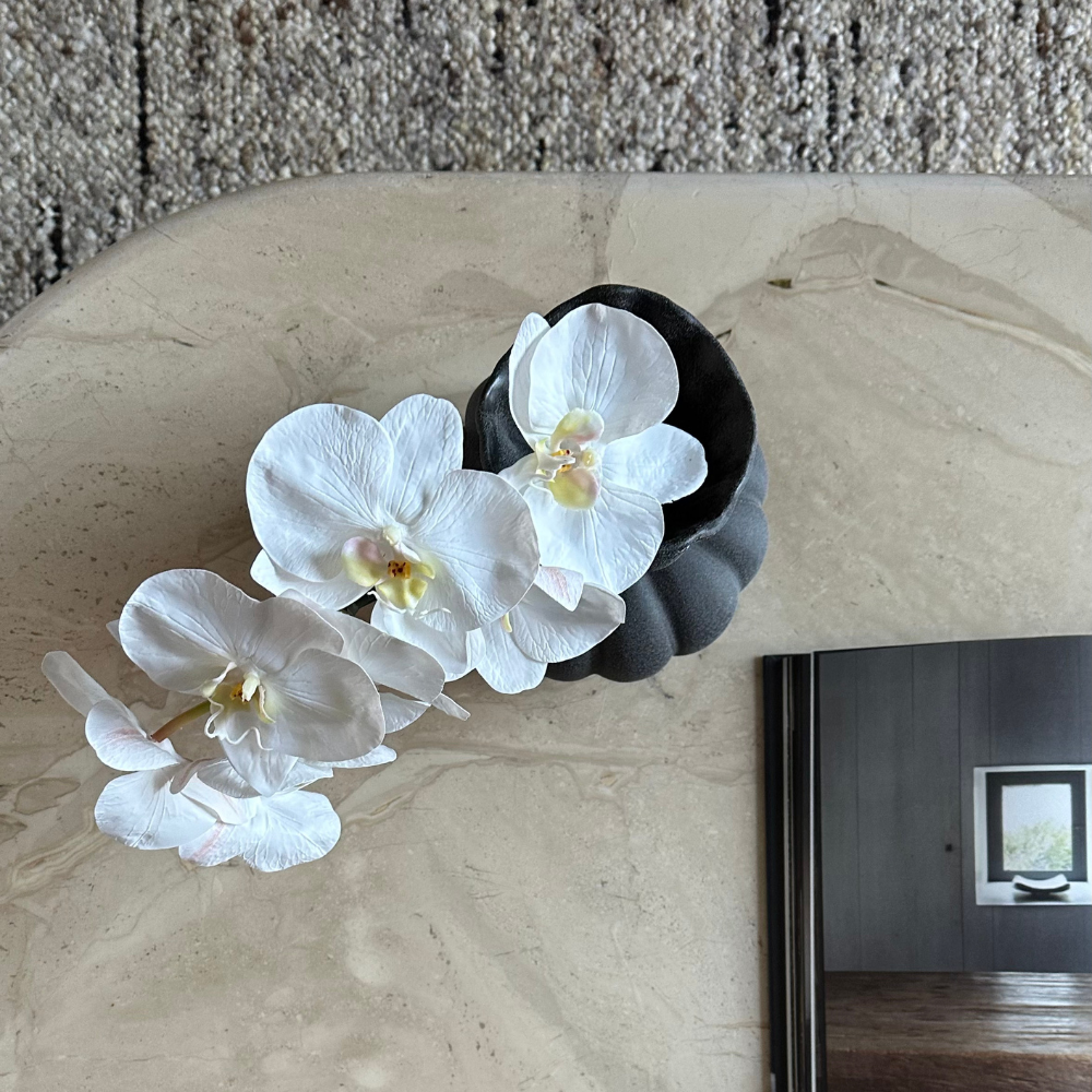 Top view of White Real-touch Phalaenopsis Orchid in black ceramic vase